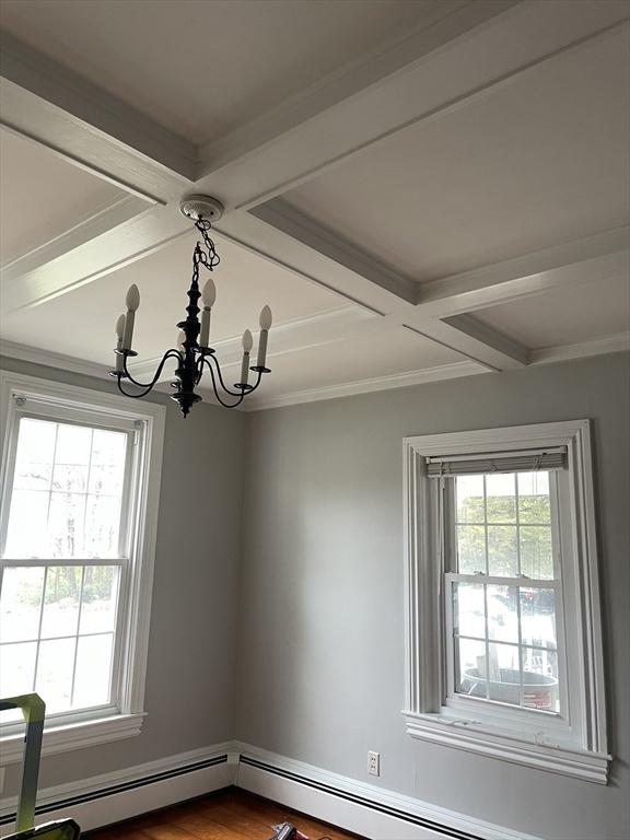details featuring crown molding, a baseboard radiator, beamed ceiling, a notable chandelier, and coffered ceiling