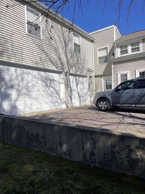 view of home's exterior featuring an attached garage and driveway