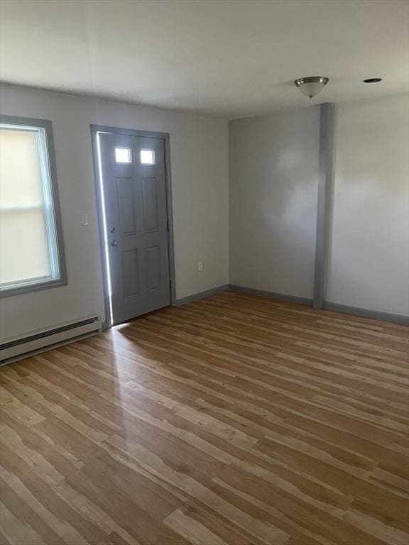 foyer with baseboards, a baseboard heating unit, and wood finished floors