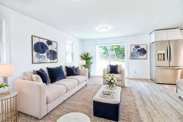 living room featuring light wood-type flooring and baseboards
