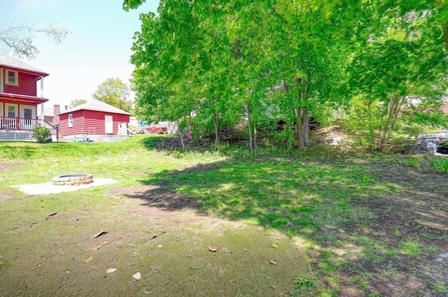 view of green lawn featuring a fire pit