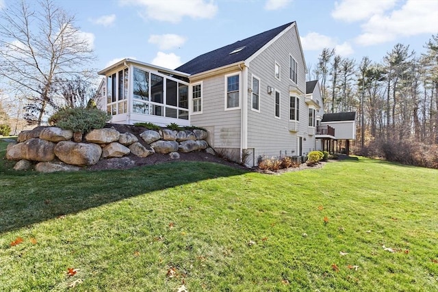 view of property exterior featuring a sunroom and a lawn