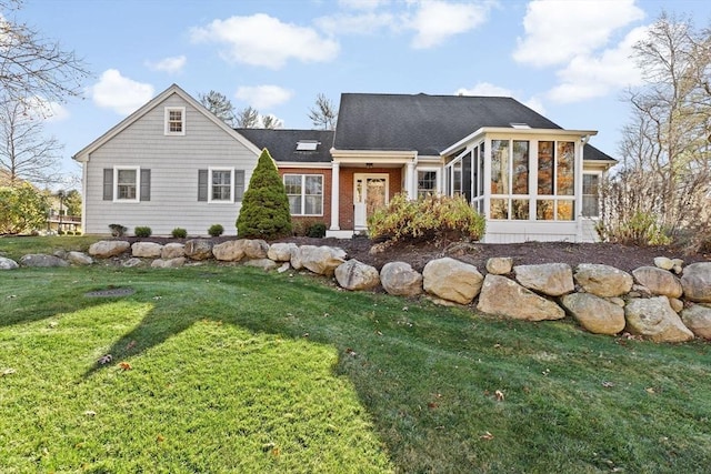 back of house with a sunroom and a lawn