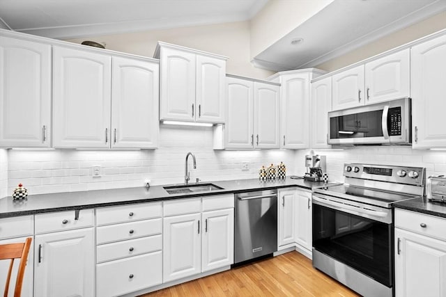 kitchen featuring tasteful backsplash, white cabinetry, sink, and stainless steel appliances