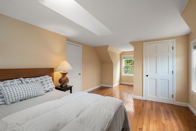 106 Nevada St, Newton, MA 02460 - bedroom with light wood-style flooring, baseboards, a skylight, and lofted ceiling