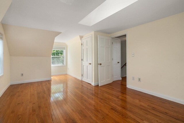 106 Nevada St, Newton, MA 02460 - additional living space with wood-type flooring, baseboards, lofted ceiling, and a skylight