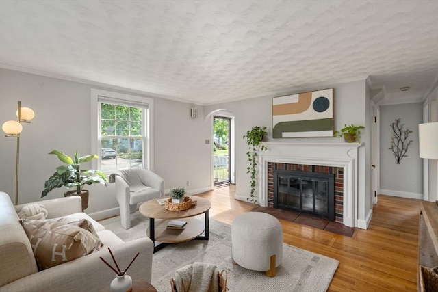 106 Nevada St, Newton, MA 02460 - living room featuring wood finished floors, a fireplace, crown molding, baseboards, and arched walkways