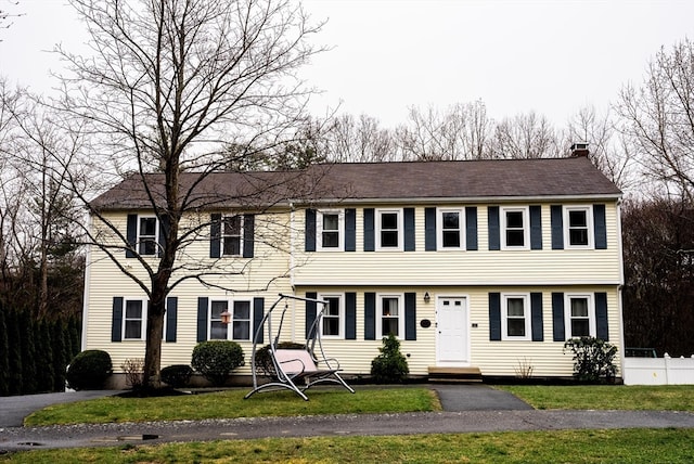 colonial house featuring a front lawn