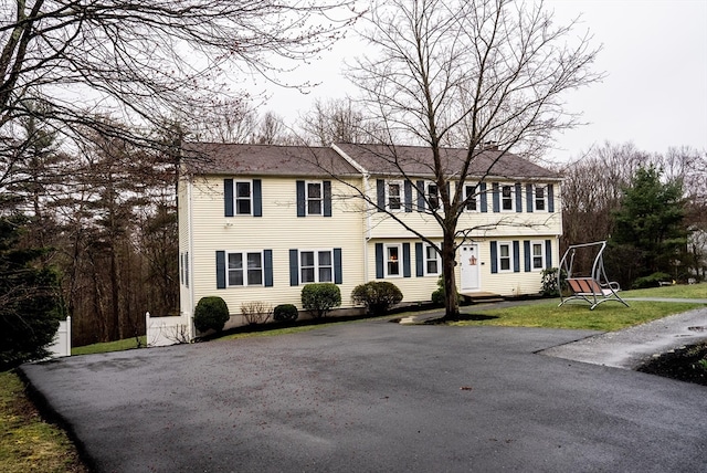 colonial home featuring a front lawn