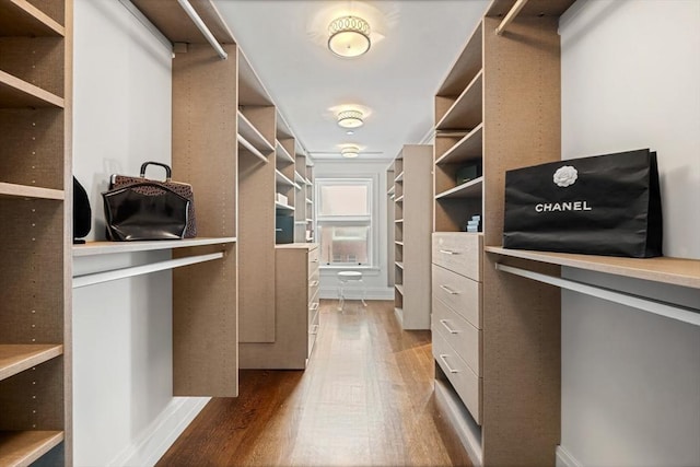 walk in closet with wood finished floors