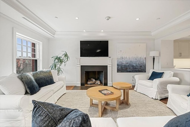 living area with a fireplace with flush hearth, ornamental molding, wood finished floors, and recessed lighting