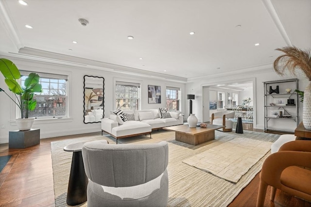 living area featuring a healthy amount of sunlight, ornamental molding, and wood finished floors