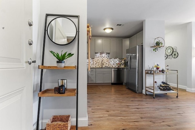 4 Harvest Dr Unit 225, North Andover, MA 01845 - kitchen with gray cabinets, appliances with stainless steel finishes, light wood-style floors, and decorative backsplash