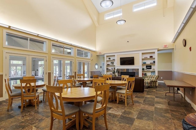 4 Harvest Dr Unit 225, North Andover, MA 01845 - dining area with a towering ceiling, french doors, a tiled fireplace, and stone finish floors