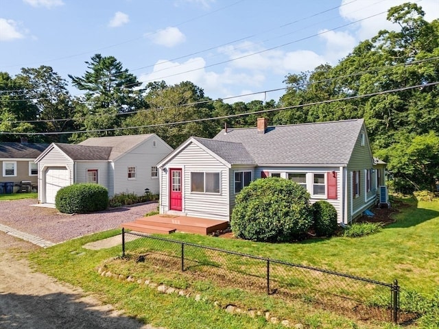 single story home with cooling unit, a front lawn, a garage, and an outbuilding