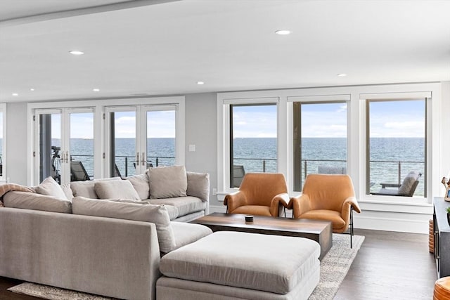 living room with a water view, french doors, recessed lighting, and wood finished floors