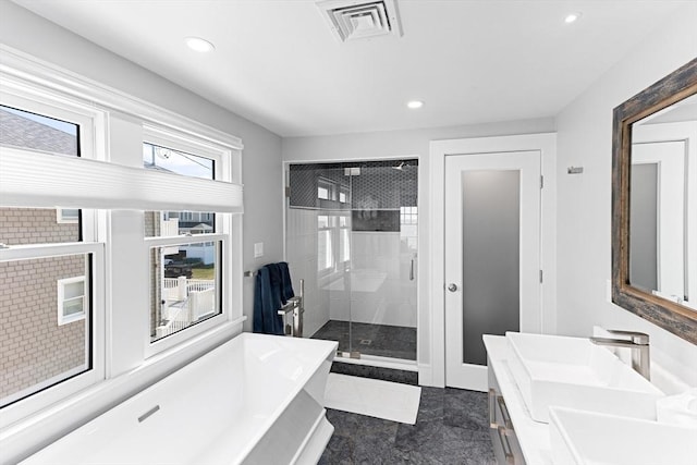 full bathroom featuring a freestanding tub, a stall shower, recessed lighting, visible vents, and a sink
