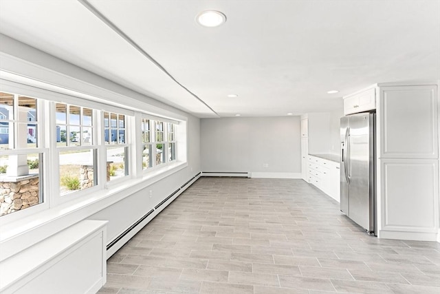 interior space featuring a baseboard heating unit, baseboards, and recessed lighting