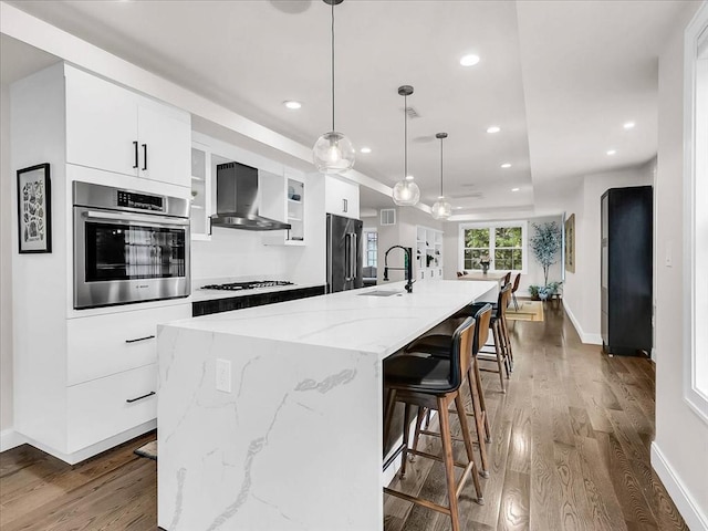 72-74 Grafton St Unit 2, Arlington, MA 02474 - kitchen with stainless steel appliances, wall chimney range hood, a sink, wood finished floors, and recessed lighting