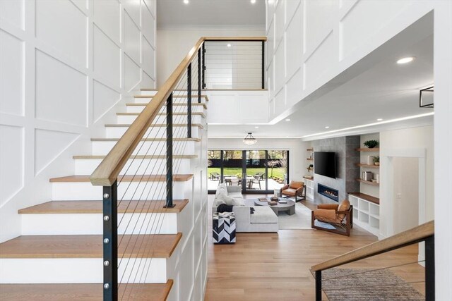 7 Fulton Rd, Lexington, MA 02420 - stairs with crown molding, a fireplace, recessed lighting, wood finished floors, and a towering ceiling