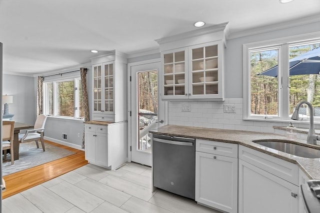 kitchen with white cabinetry, a sink, dishwasher, crown molding, and tasteful backsplash