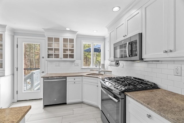 kitchen featuring a sink, crown molding, white cabinetry, and stainless steel appliances