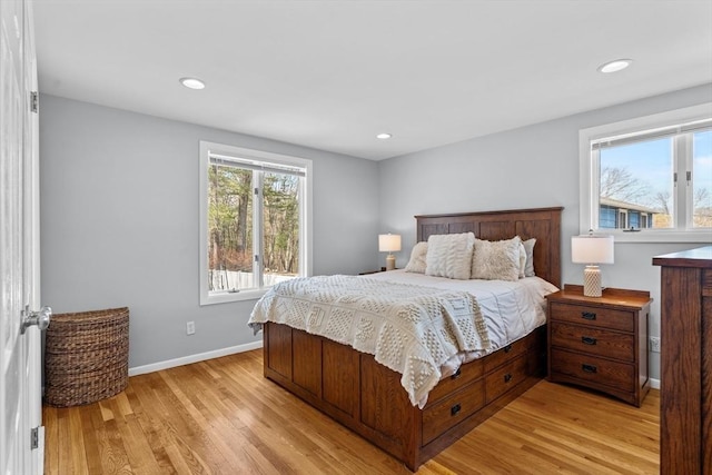 bedroom featuring recessed lighting, baseboards, multiple windows, and light wood-style floors