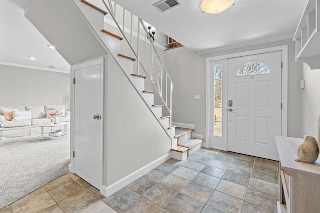 entryway with stairs, light colored carpet, visible vents, and ornamental molding