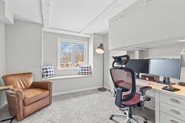 office space featuring carpet flooring, visible vents, baseboards, and a textured wall