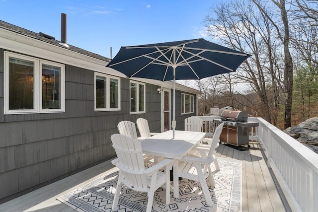 wooden terrace featuring outdoor dining area and a grill