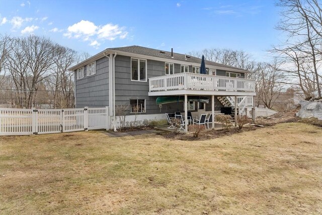 rear view of property with a patio, a lawn, a deck, and fence