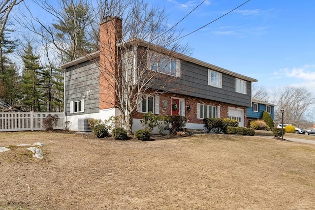 view of front facade with central AC unit, fence, brick siding, and a chimney