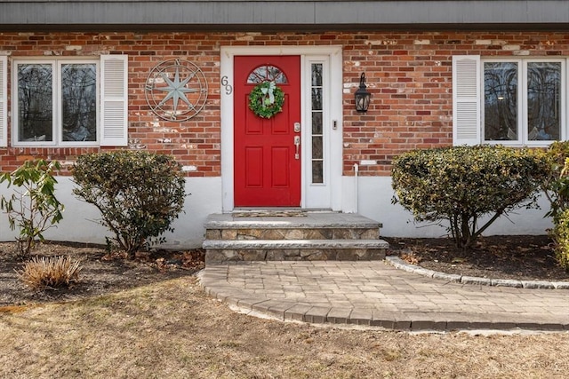 view of exterior entry featuring brick siding