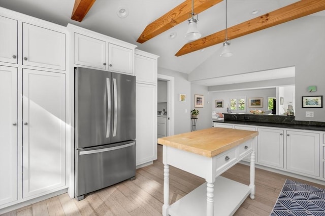 kitchen featuring freestanding refrigerator, independent washer and dryer, white cabinets, light wood finished floors, and hanging light fixtures