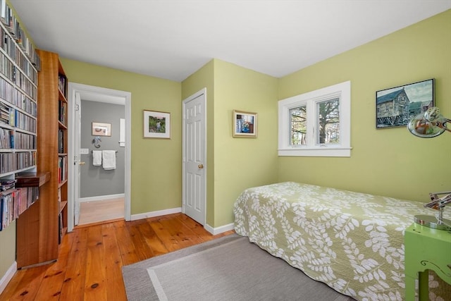bedroom with wood-type flooring and baseboards