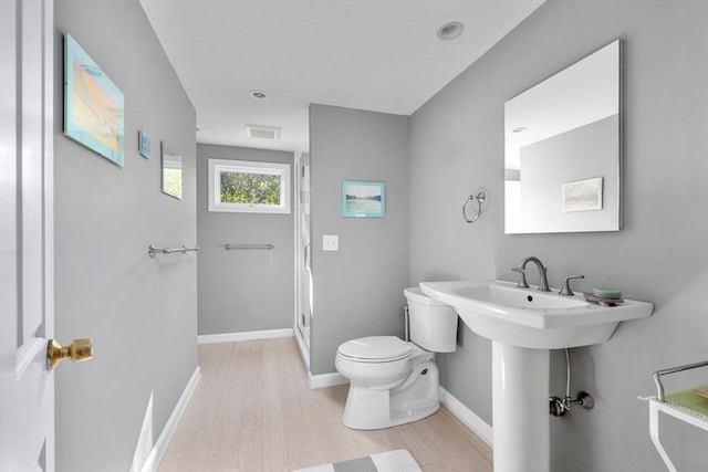 full bath featuring baseboards, toilet, wood finished floors, and a shower stall