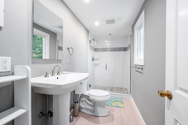 full bath featuring a shower stall, toilet, wood finished floors, and baseboards
