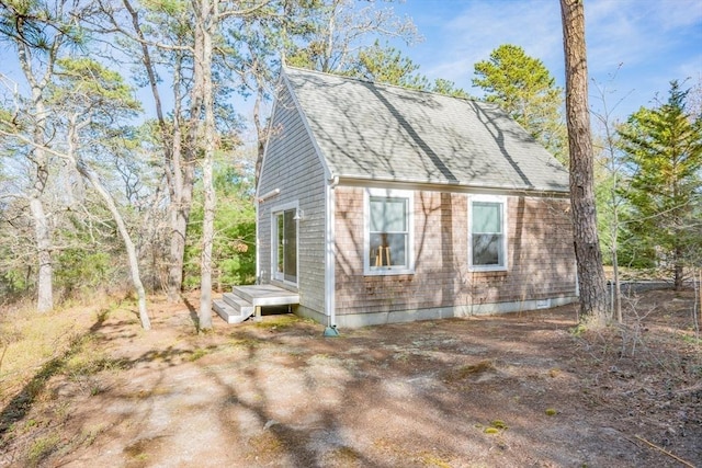view of property exterior with a shingled roof
