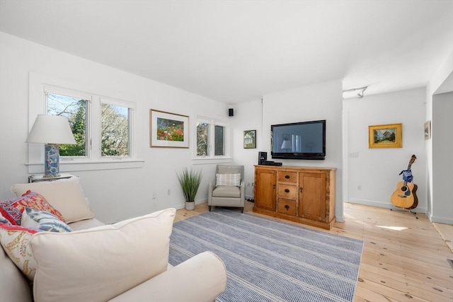 living area featuring light wood-type flooring and baseboards