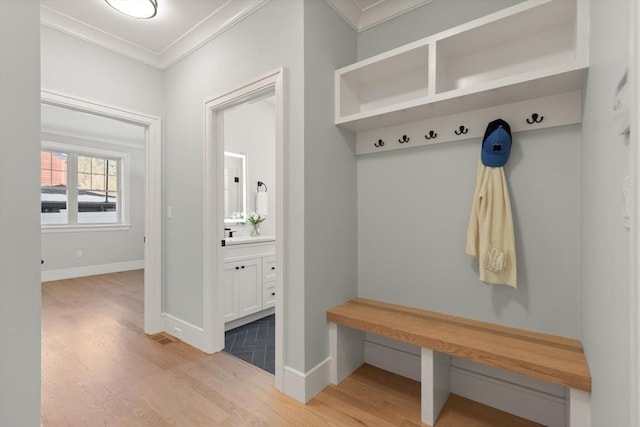 mudroom featuring ornamental molding and light hardwood / wood-style floors