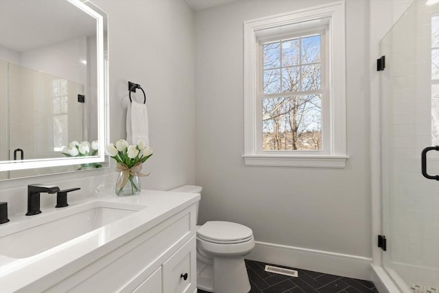 bathroom featuring toilet, tile patterned flooring, walk in shower, and vanity