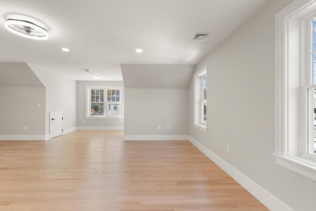 bonus room featuring light hardwood / wood-style flooring, lofted ceiling, and plenty of natural light