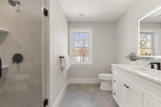 bathroom with parquet floors, a shower, vanity, and toilet