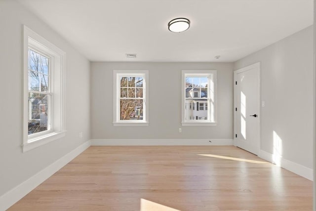 unfurnished room featuring light hardwood / wood-style floors and a wealth of natural light