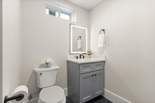 bathroom with toilet, tile patterned flooring, and vanity