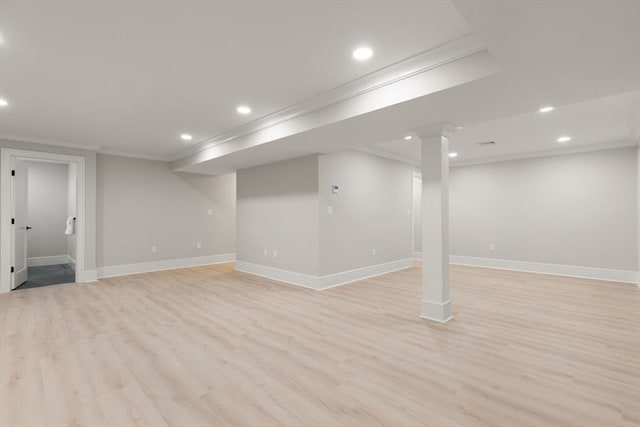 basement featuring light hardwood / wood-style floors and crown molding