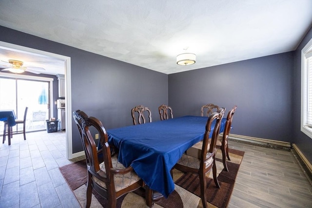dining area with wood finish floors, plenty of natural light, baseboards, and ceiling fan