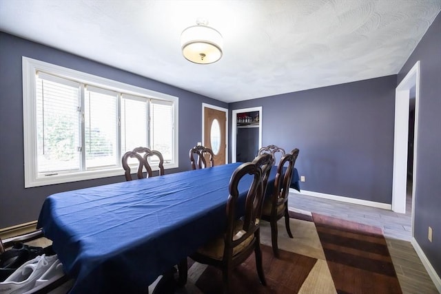 dining area with baseboards and wood finished floors