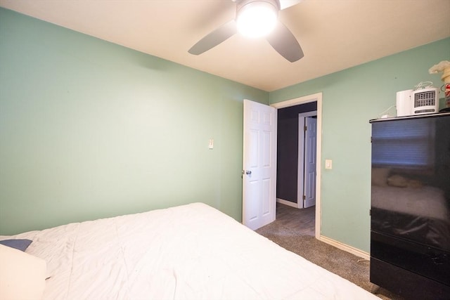 carpeted bedroom with ceiling fan and baseboards