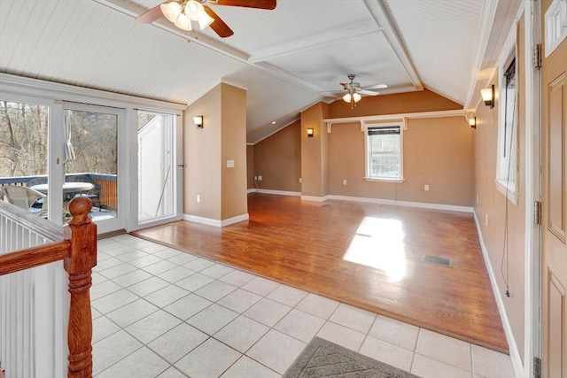 interior space with ceiling fan, a healthy amount of sunlight, lofted ceiling, and light tile patterned floors